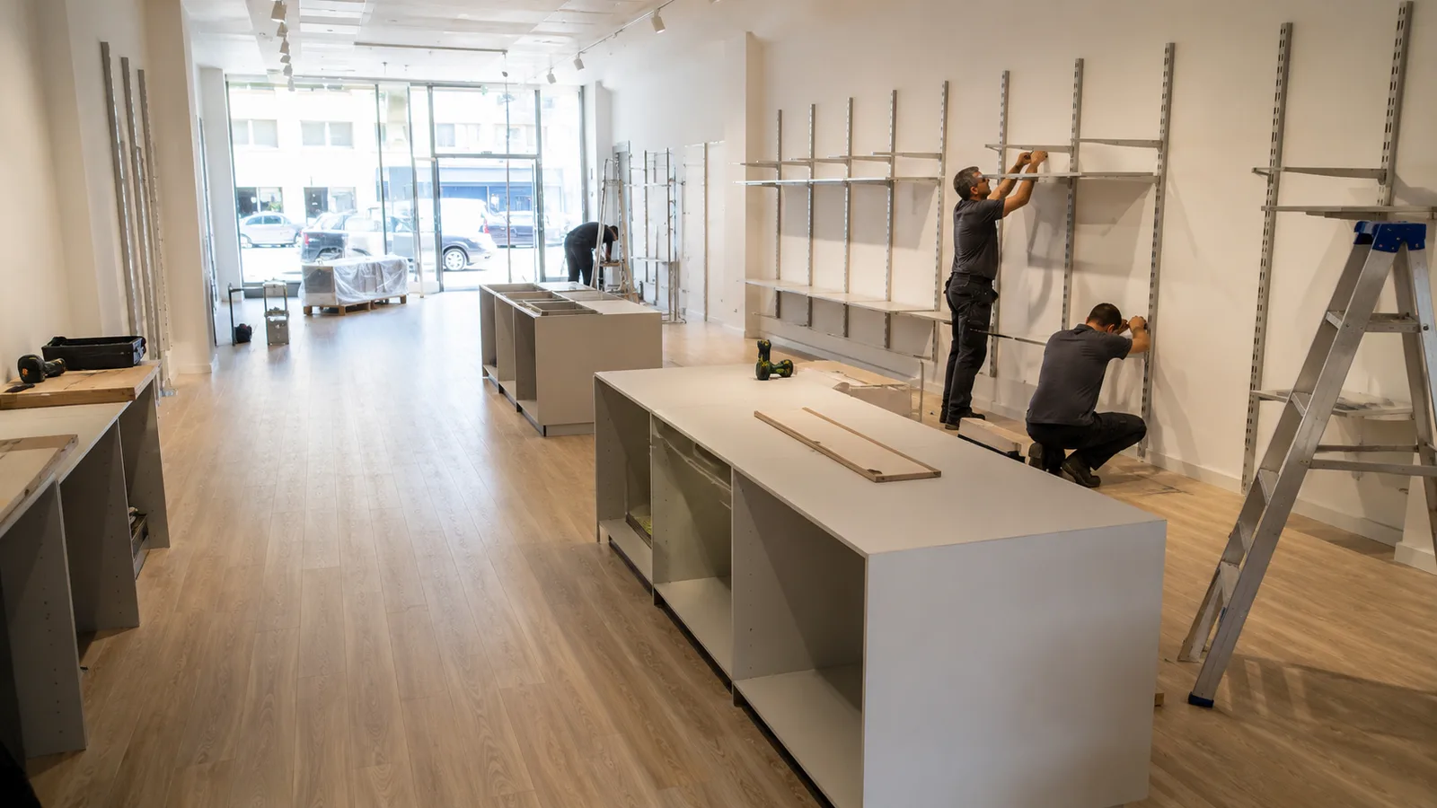 Cantiere in fase avanzata con scaffalature in installazione presso punto vendita retail pronta all'apertura
